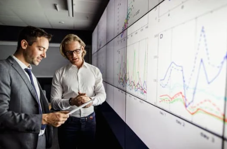 Engineer analyzing vibration data on a computer screen with machinery in the background